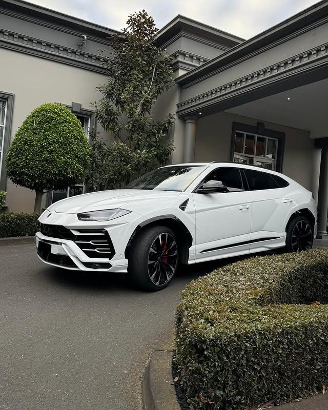 White Lamborghini Urus wedding car outside a home