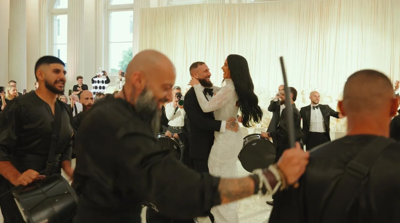 Bride and groom dancing while drummers perform around them