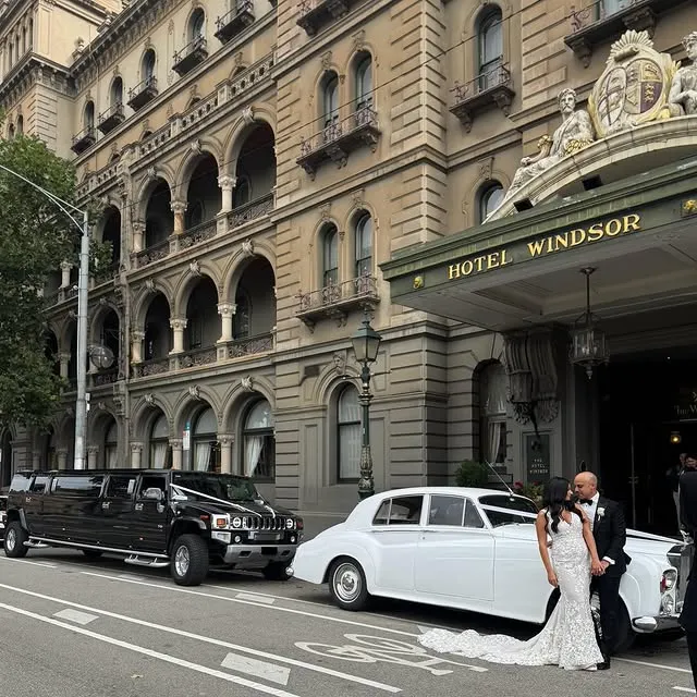 Bride and groom outside Hotel Windsor with wedding cars