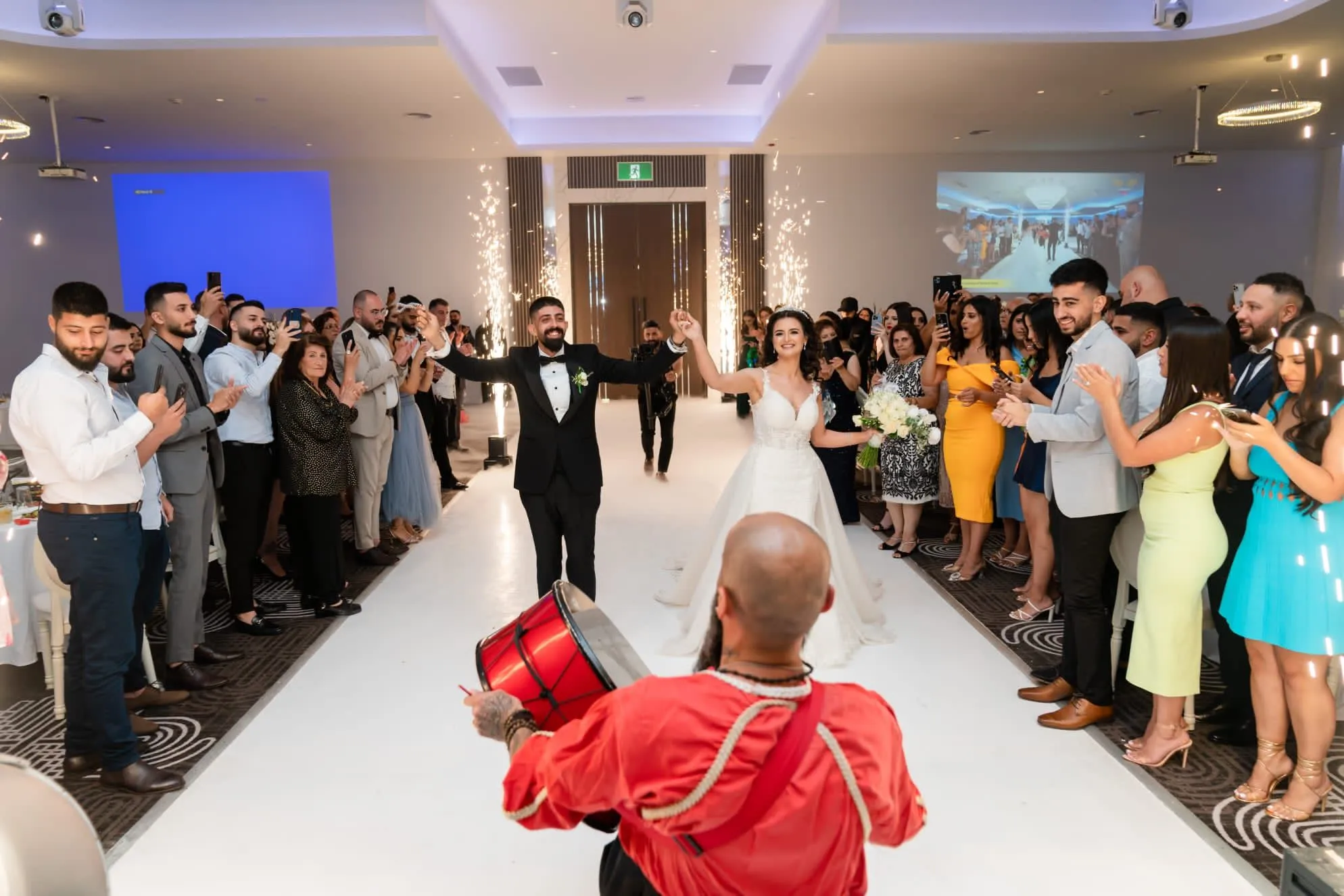 Bride and groom entering their wedding reception with a drummer