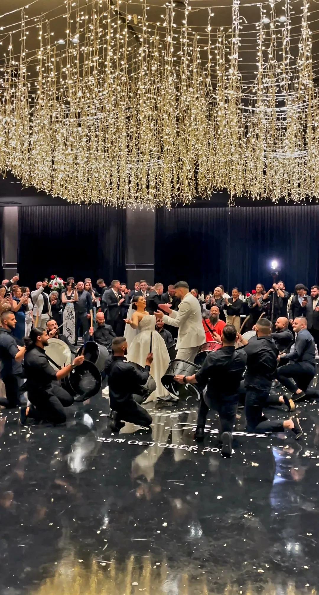 Drummers performing in a circle before a large reception crowd