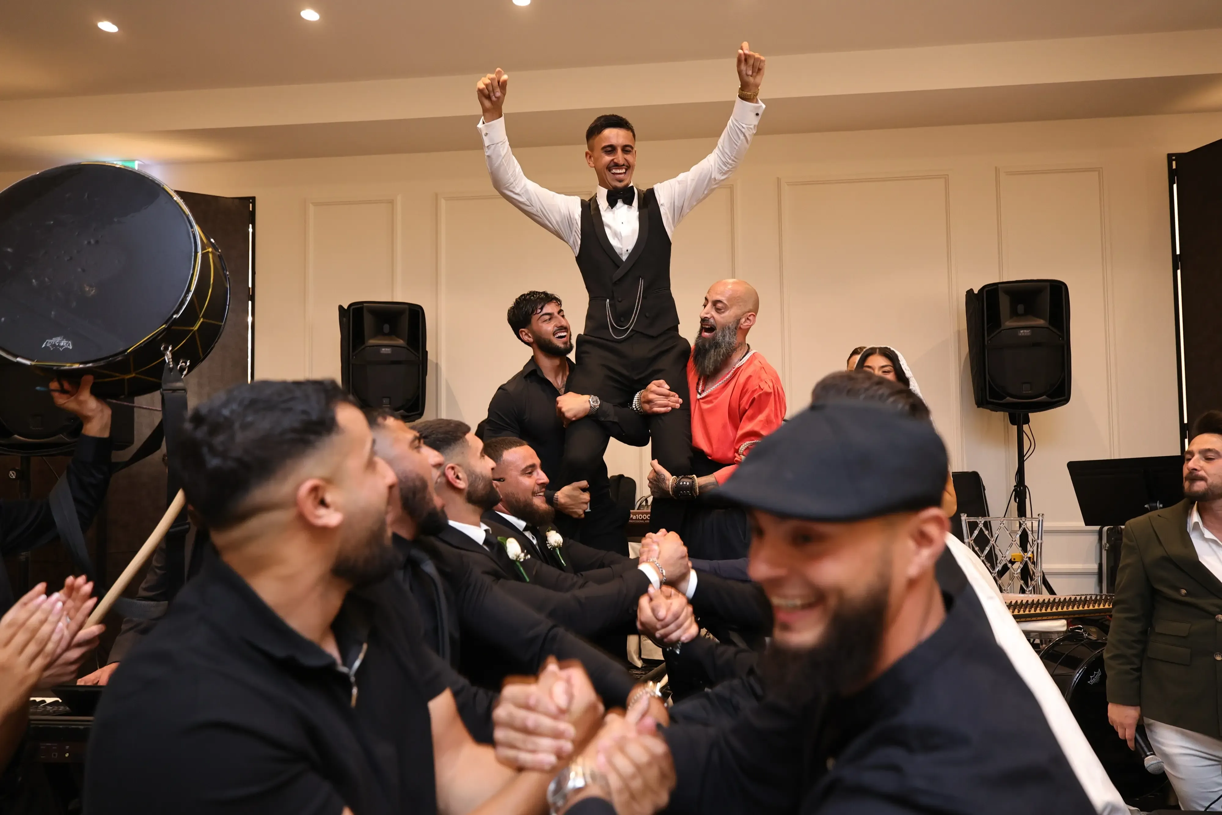 Groom being held up at party