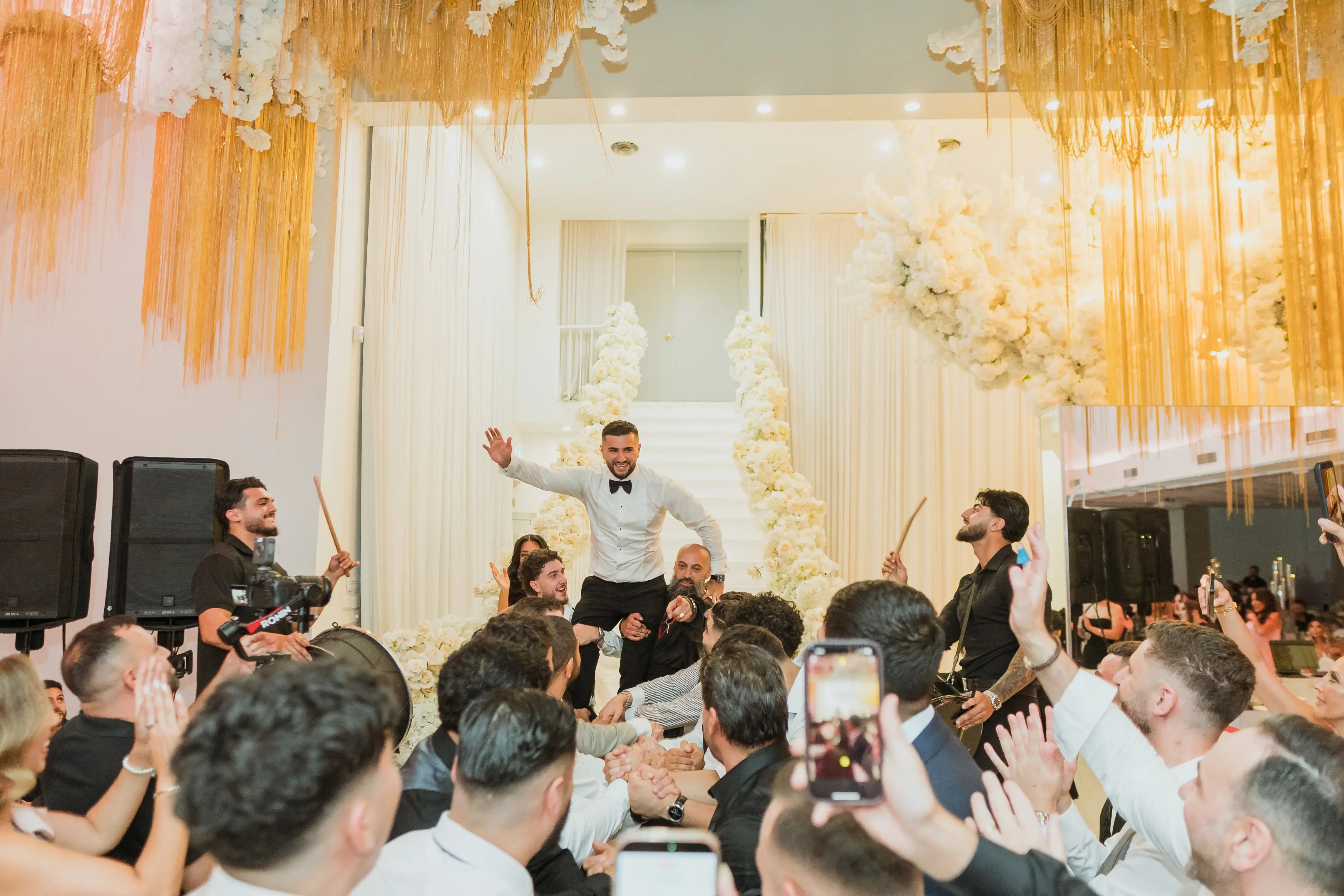 Groom raised above the wedding crowd during a dance