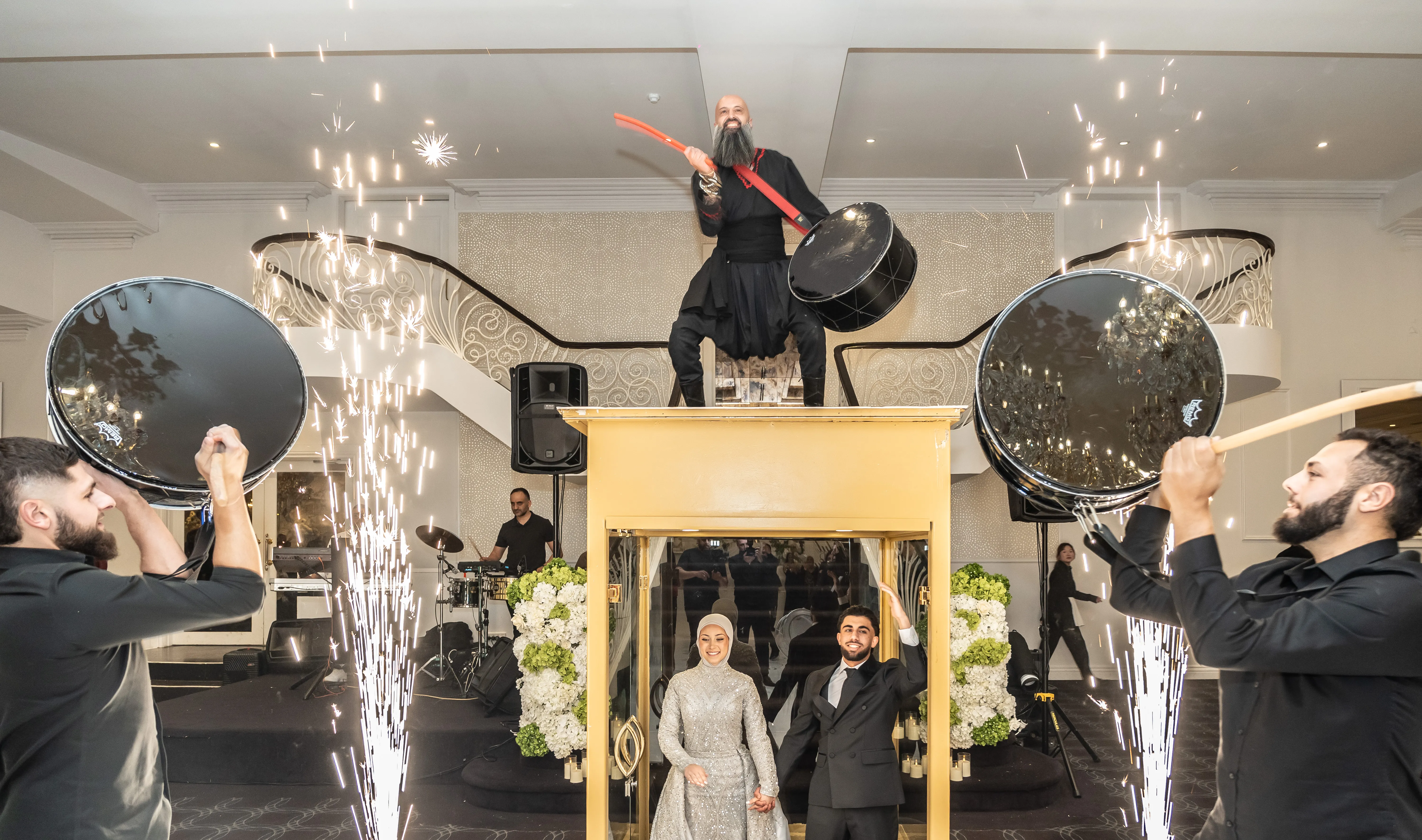 IAMNSA performing on a stage lift with drummers and sparklers
