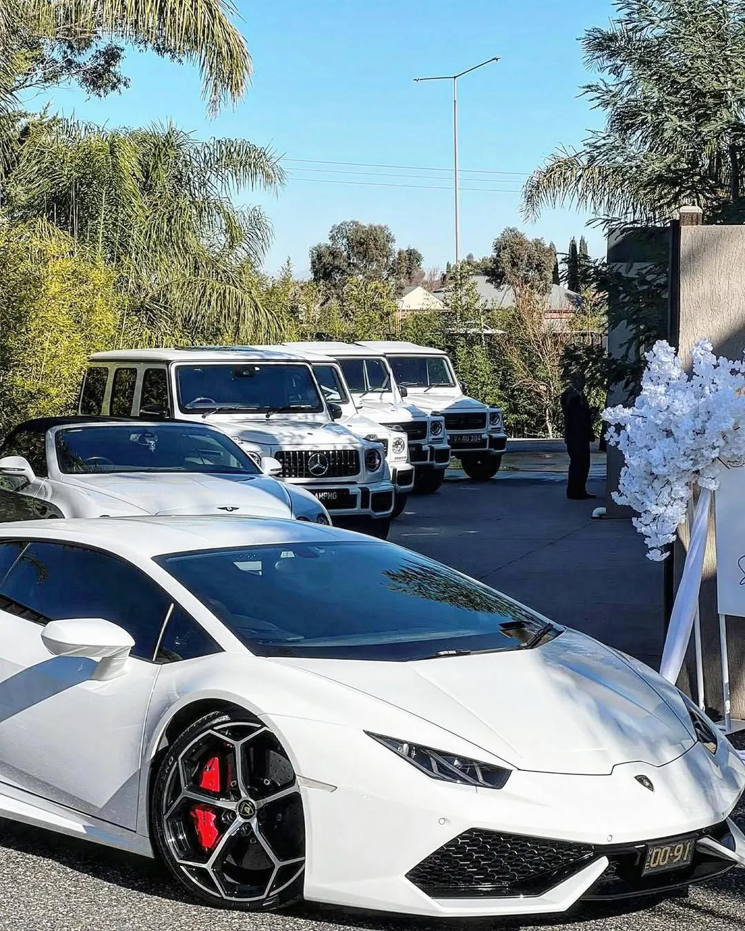 Luxury wedding car fleet at a floral entrance