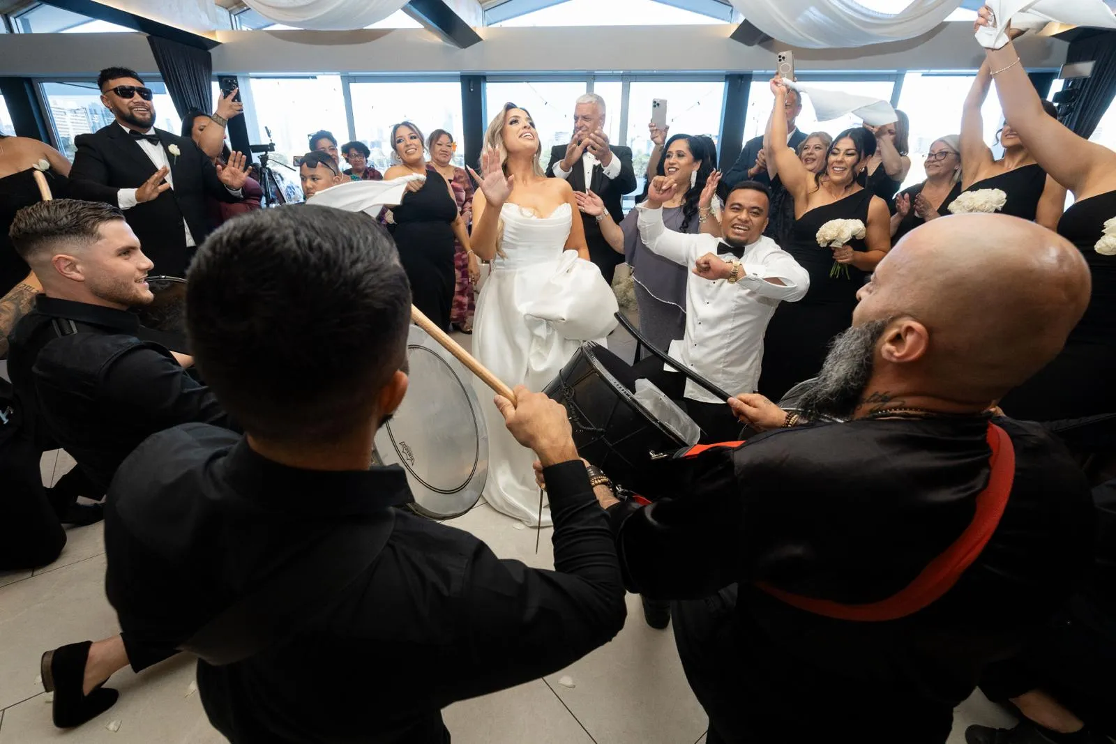 Bride dancing with guests and drummers at a wedding reception