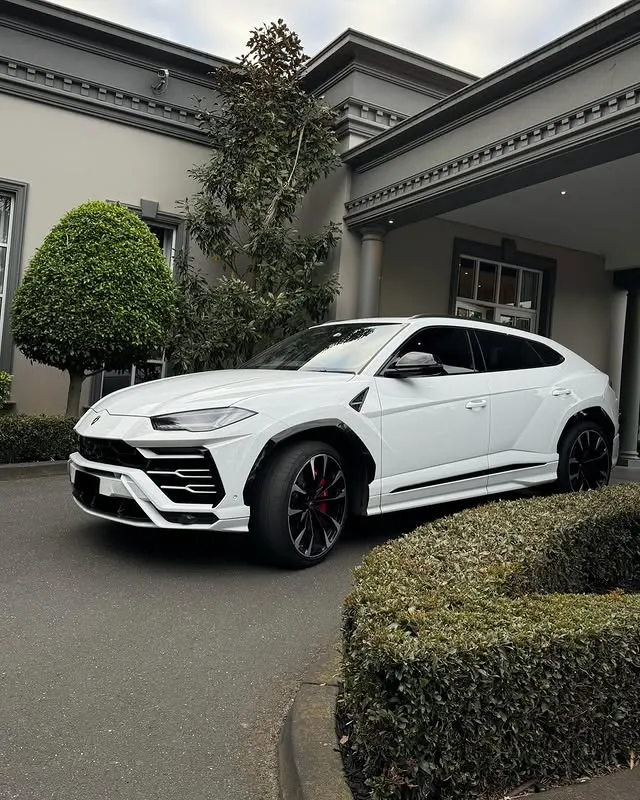 White Lamborghini Urus wedding car outside a home